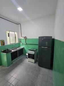 a green and white kitchen with a sink and a refrigerator at Pousada Hostel Beach Pajuçara in Maceió +29 photos