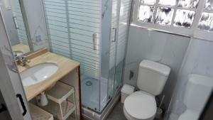 een badkamer met een wastafel en een toilet en een raam bij Casa de Huéspedes Providencia Baquedano in Santiago