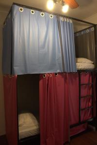 een slaapkamer met 2 stapelbedden en een baldakijn bij Sakura Hostel in Poços de Caldas