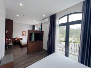 a hotel room with a bed and a large window at Kapás Hotel in Hai Phong
