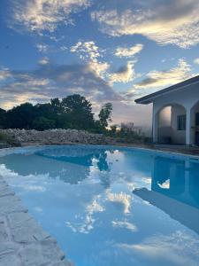 een zwembad met blauw water voor een huis bij Mangoverde Guesthouse in Moalboal