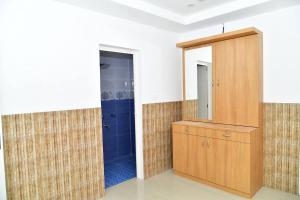 a bathroom with a wooden cabinet and a mirror at Orchid Woods Room in Trivandrum