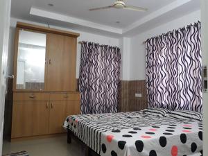 a bedroom with a bed with black and white sheets at Orchid Woods Room in Trivandrum