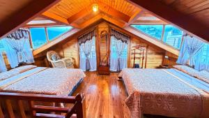 a bedroom with two beds in a attic at Cabaña Real in Ibarra +15 photos