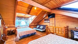 a bedroom with two beds and a couch in a room at Cabaña Real con Yacuzzi rodeada de pavos reales in Ibarra