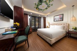 een hotelkamer met een bed, een bureau en een computer bij Golden Legend Palace Hotel & Travel in Hanoi