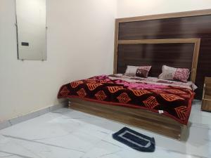 a bed with a wooden headboard in a room at Naval Kishori Kunj in Vrindāvan +10 photos