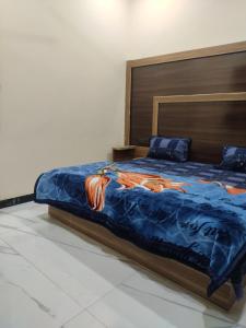a bedroom with a bed with a blue comforter at Naval Kishori Kunj in Vrindāvan