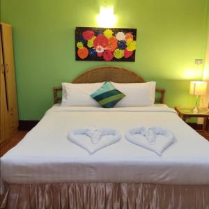 a bed with two hearts shaped towels on it at Victoria Hotel in Hua Hin