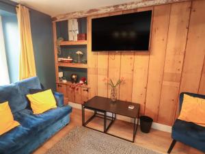 een woonkamer met een blauwe bank en een tafel bij 10 Keekle Terrace in Cleator Moor