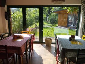 une salle à manger avec tables et chaises et une grande fenêtre dans l'établissement Marina - Camp pod kaštany, à Morávka