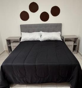 a bedroom with a black bed with two end tables at Departamento PA in Villa Carlos Paz