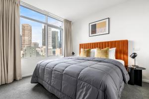 a bedroom with a bed and a large window at Nolo Apartments Lonsdale St in Melbourne +54 photos