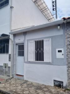 een wit huis met een deur en een raam bij Casa da Bisa Ubatuba in Ubatuba