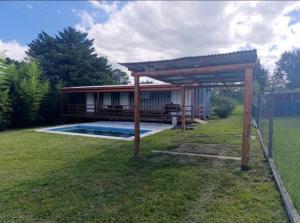 a house with a swimming pool and a pergola at Cabaña Habibi in Potrero de Garay