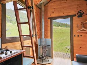 a kitchen with a stove and a ladder in a room at Anakie Gorge Getaway Tiny House 1 by Tiny Away in Staughton Vale +3 photos