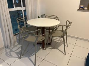 a table and chairs in a room with a window at Village do Sol 3 - Apt compartilhado in Maioba +6 photos