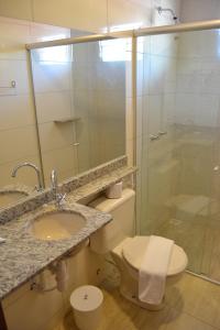a bathroom with a shower and a toilet and a sink at Pousada Beija Flores in Porto De Galinhas