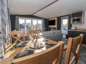 een eetkamer met een tafel en stoelen en een keuken bij Meadows Park 3 in Hull