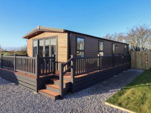 een tiny house met een veranda en een terras bij Meadows Park 3 in Hull