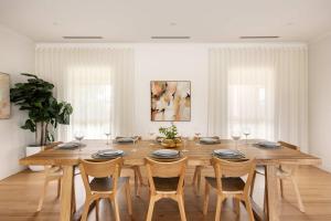 a dining room with a wooden table and chairs at Play on Balcombe in Mount Martha