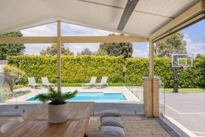 an outdoor patio with a pool and a basketball hoop at Play on Balcombe in Mount Martha