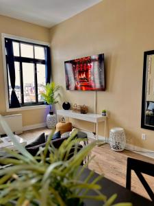 a living room with a couch and a tv on the wall at The Nest At Twelve in Detroit