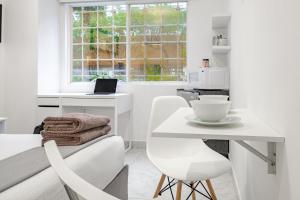 een witte keuken met een tafel en een witte stoel bij Casa Ama in Mexico-Stad