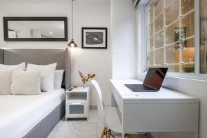 een slaapkamer met een bureau en een laptop op een bed bij Casa Ama in Mexico-Stad