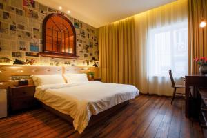 a bedroom with a large bed and a window at Kaiyue Hotel Qingdao in Qingdao