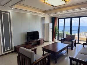 TrinitySeaview Garden Hotel & Residences的配有电视、桌椅的客厅