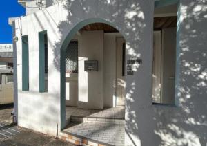 宫古岛女性専用 dormitory all good的带有拱门的白色建筑的入口