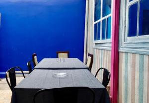 een tafel en stoelen in een kamer met een blauwe muur bij Casa de Huéspedes Providencia Baquedano in Santiago +41 foto's