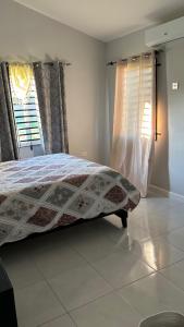 una camera da letto con un letto e una finestra di New Cozy Entire home 2 Bedroom- AC, Wifi, 24 hour Security in Private Gated Community a Old Harbour Altre 9 foto