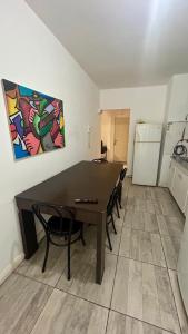 a dining room with a table and chairs and a refrigerator at Satya park in Mar del Plata