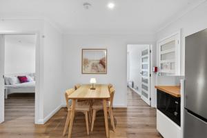 a kitchen and dining room with a table and chairs at Garigal Retreat with Pool access and EV Station in Forestville