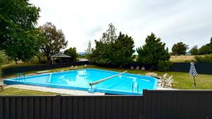 een groot blauw zwembad in een tuin bij Mt Aspiring Home in Wanaka