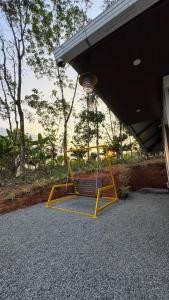 a yellow swing hanging from a porch of a house at Riverfolk Stays in Thodupuzha