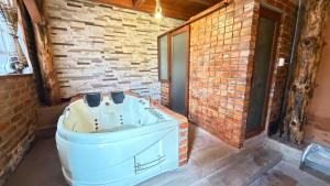 a bath tub in a room with a brick wall at Cabaña Real in Ibarra