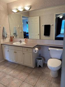 een badkamer met een wastafel, een toilet en een spiegel bij Cozy getaway with a view! in Fairmont Hot Springs +33 foto's