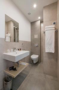 a bathroom with a toilet, sink, and shower at Hotel Reytan in Warsaw