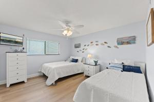 een slaapkamer met twee bedden en een plafondventilator bij Canaveral Sands 4202 in Cape Canaveral +20 foto's