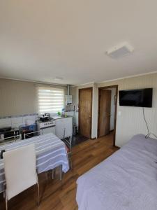 Zimmer mit einem Bett und einer Küche mit einem TV in der Unterkunft Cabaña 2 a 4 personas in Carahuo