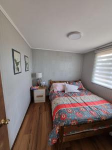 ein kleines Schlafzimmer mit einem Bett und einem Fenster in der Unterkunft Cabaña 2 a 4 personas in Carahuo