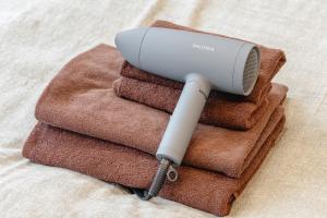 un asciugacapelli su una pila di asciugamani di 365Ueno a Tokyo