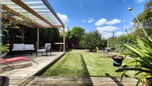 a patio with chairs and a table and grass at Charmante maison t3 avec 2 chambres et jardin clos in Carquefou