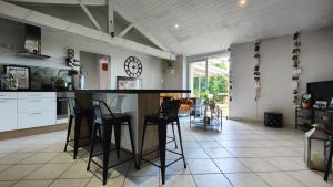 a kitchen with a counter and stools in a room at Charmante maison t3 avec 2 chambres et jardin clos in Carquefou