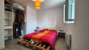 a bedroom with a bed with a colorful blanket at Charmante maison t3 avec 2 chambres et jardin clos in Carquefou