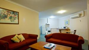 ein Wohnzimmer mit zwei Sofas und einem Tisch in der Unterkunft Motel Le Grande in Albany + 30 Fotos