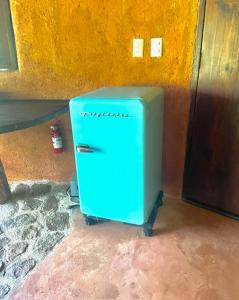 een blauwe koelkast in de hoek van een kamer bij Flor de Arena in Arroyo Cruz
